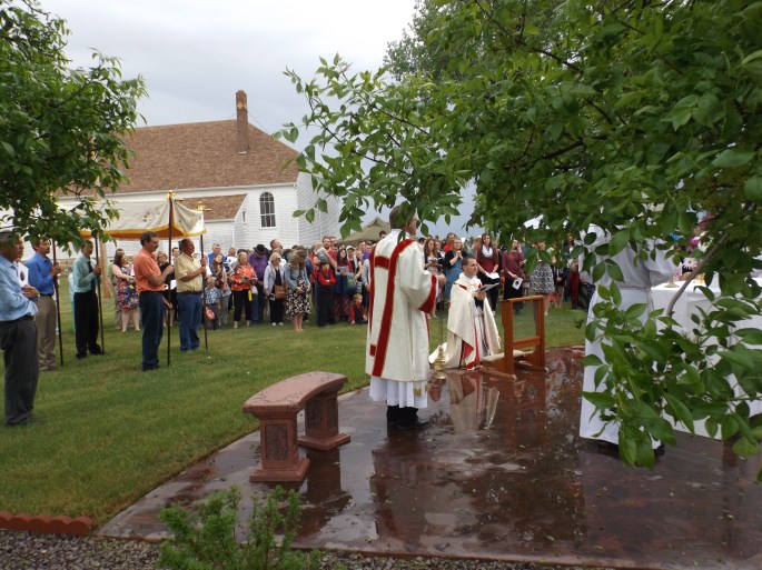 Father John Paul Gardner leads attendees in prayer at an outside altar.